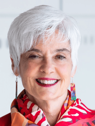 photo of Susanne Buryere, smiling and wearing a red and white scarf