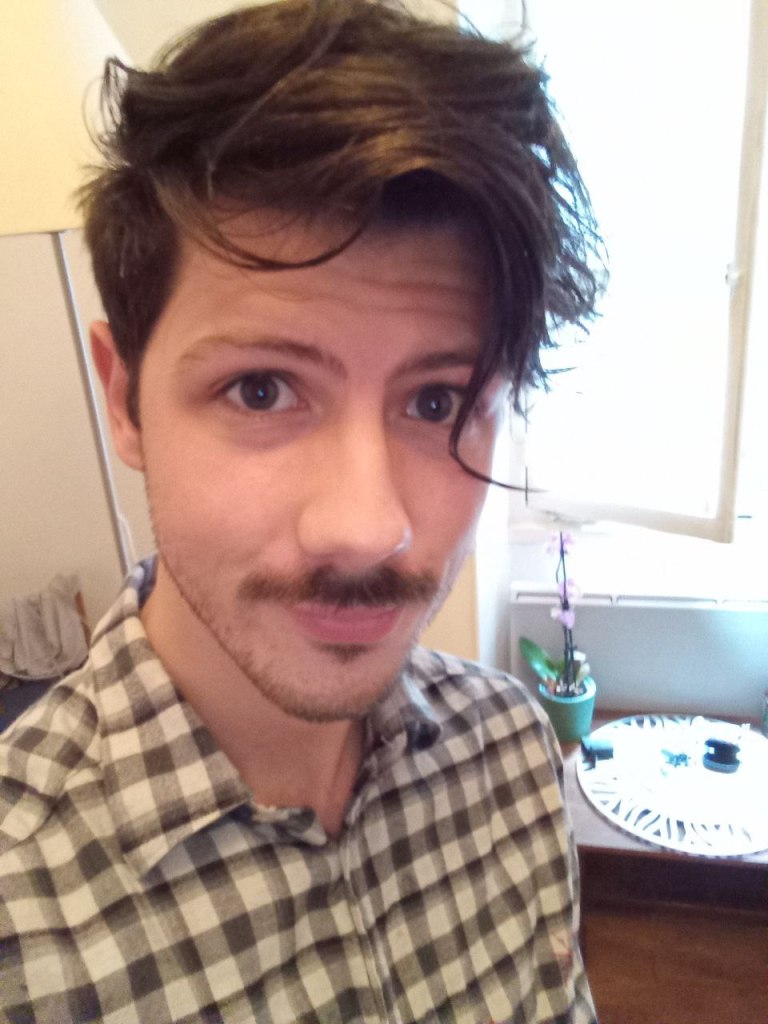 head shot of Jan-Philipp Reinecke waring a black and white top. He stands at an angle. You can see a table in the background