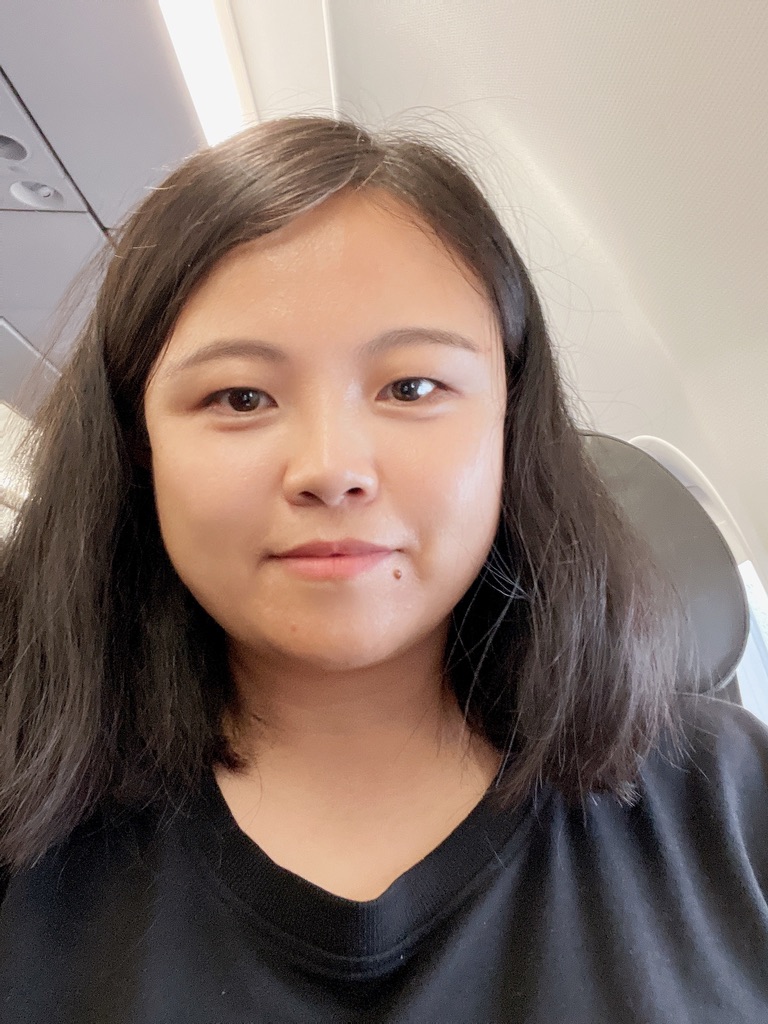 Headshot of Yi Elaine Zhang wearing a black top in front of an office background
