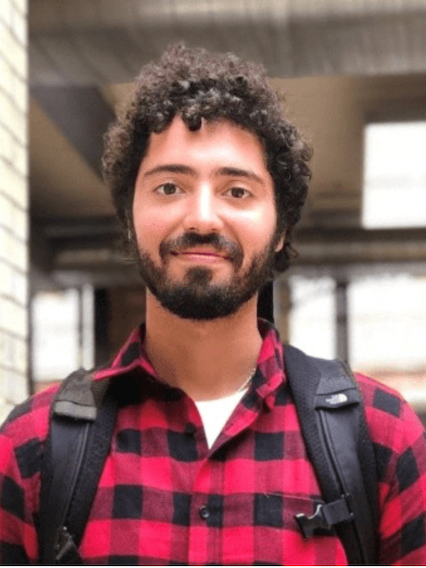 head shot of Emilio Costales wearing a black and red checkered shirt.