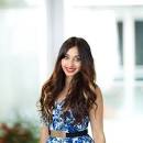 Upper Body shot of Sneer Christal, a woman with long dark hair that falls down over her black white and blue dress