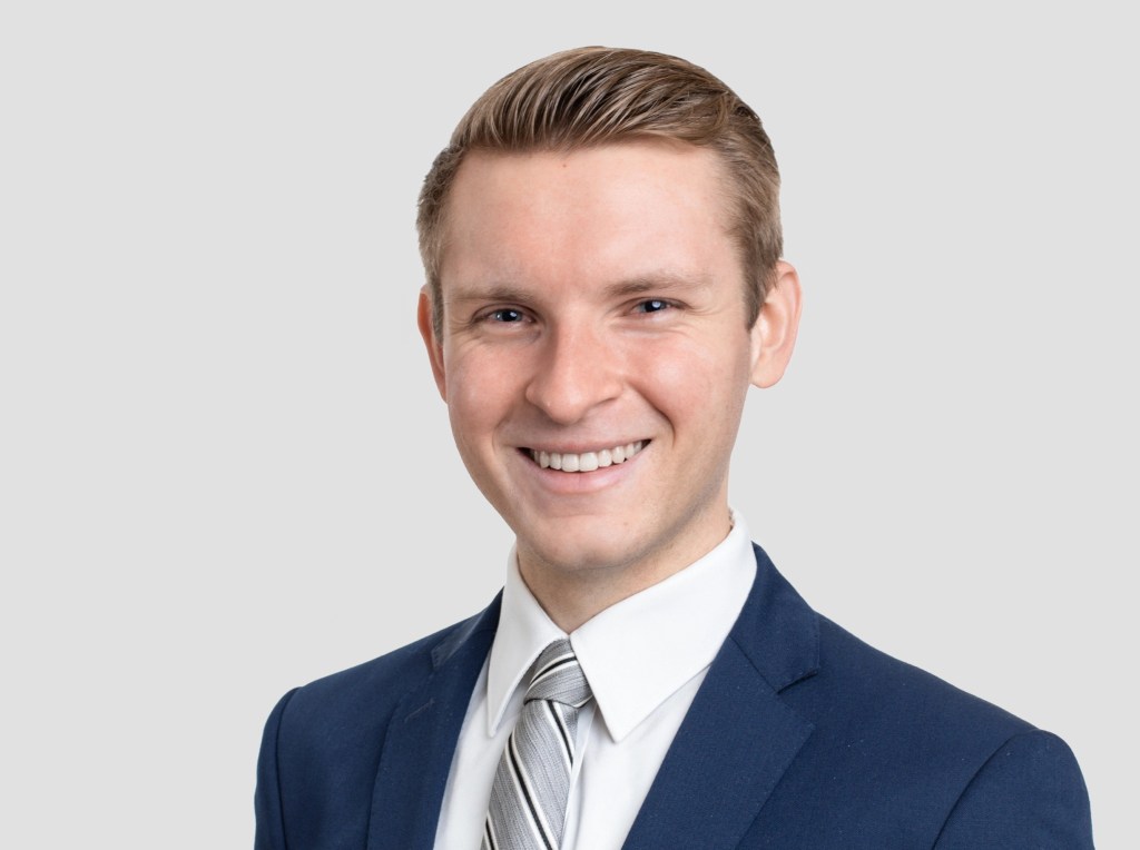 Photo of Jan Kein, a white man with short blonde hair wearing a suit and tie