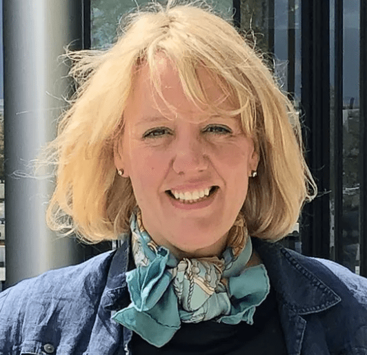 shoot of Abbie woke, a white woman whit light yellow blonde hair and a big smile. she wards a colourful scarf