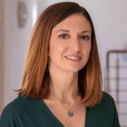 headshot of Leonie Baldacchino, a light-skinned woman with blonde-reddish hair. she wears a black top and a neckless