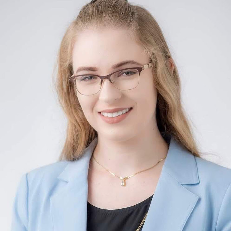head shot of Nikita Williams, a white woman with shoulder long blonde hair wearing glasses