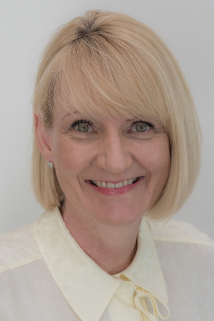Headshot of Kerri Chandler a light skinned woman with light blonde hair styled in the bob style. She smiles broadly.