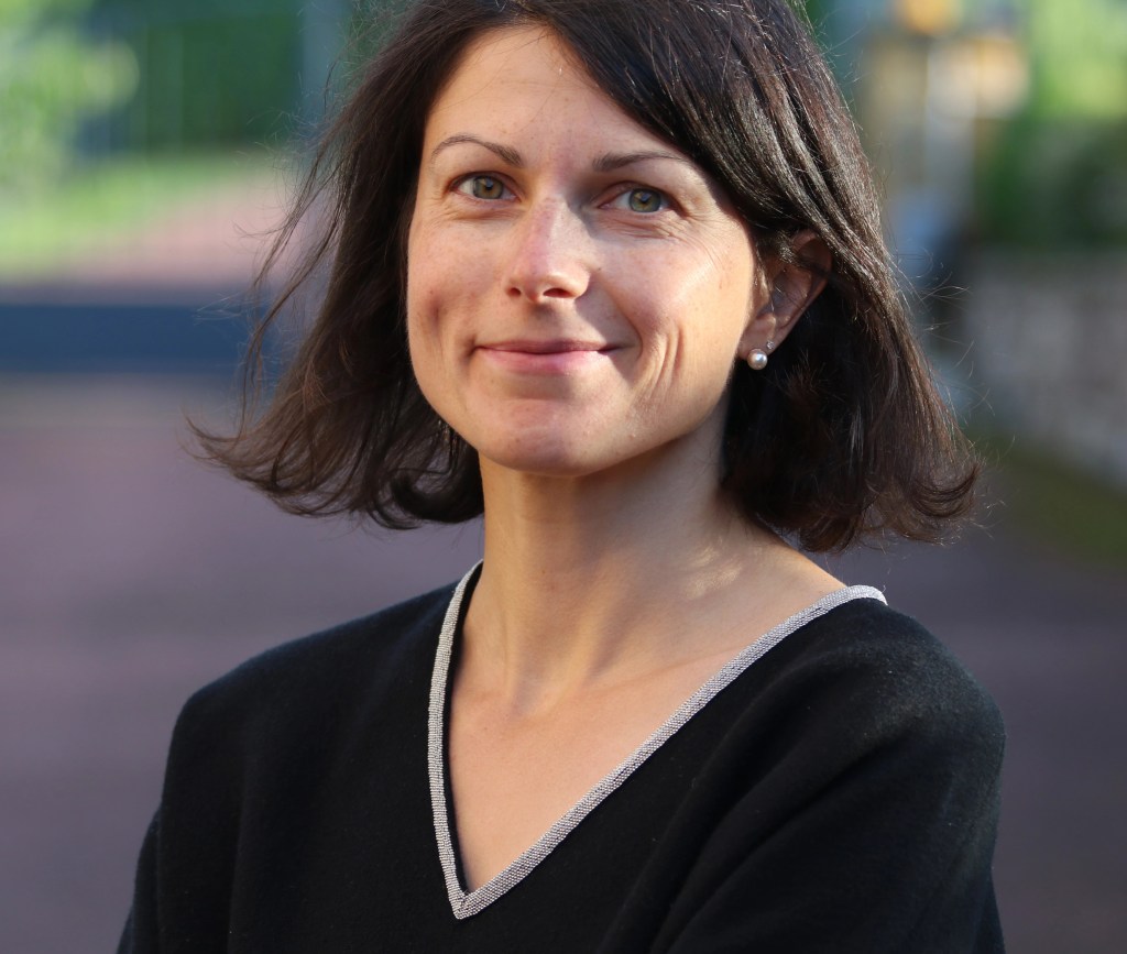 headshot of Rachel Le memos a slight skin woman with dark hair waring a black top.