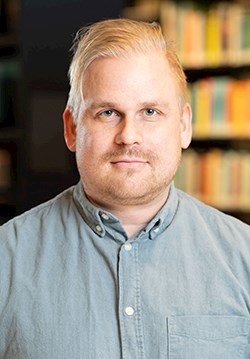 headshot of Niklas Vallström, a middle-aged white man with light blond short hair wearing a grey button up shirt
