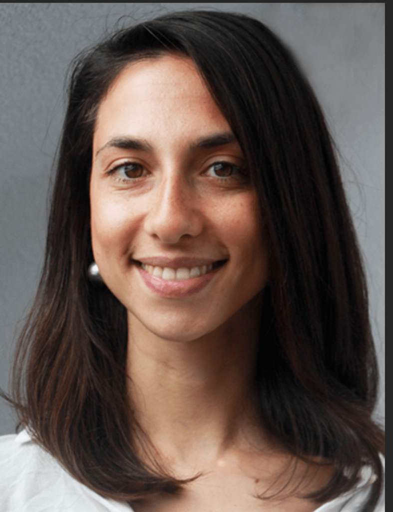 head shot of Emmanouela Mandalaki who has shoulder length dark brown hair and wears a white top