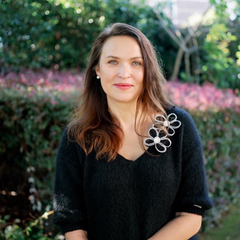 Photo of Joanna Vogeley, woman with brown long hair wearing a dark top