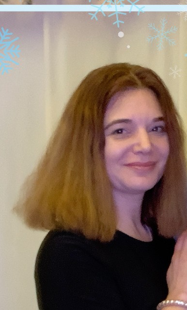 Headshot of Natalia Lorinkova. She is a White woman with long dark hair. She wears a black dress and smiles.