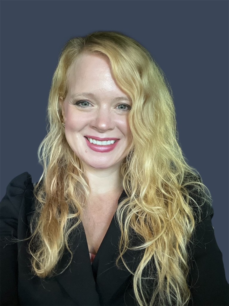 Photo of a white woman with long blonde hair smiling broadly. 