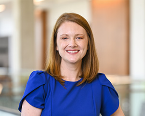Photo of a white woman with dark blonde hair smiling at the camera